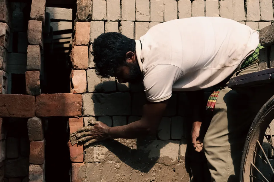Pedreiro a construir uma parede de tijolo